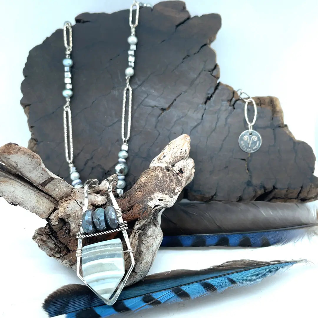 Sterling silver sparkly necklace with fresh water pearl, pyrite, and labradorite built into the chain with  a geometric pendant, featuring a blue lace agate arrow gemstone 