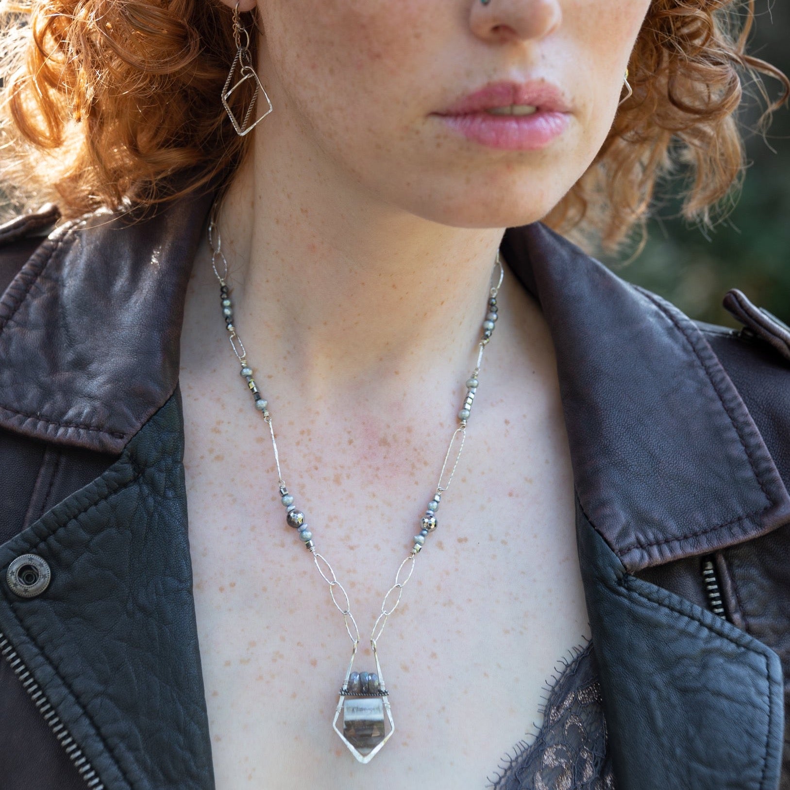 Sterling silver sparkly necklace with fresh water pearl, pyrite, and labradorite built into the chain with  a geometric pendant, featuring a blue lace agate arrow gemstone 