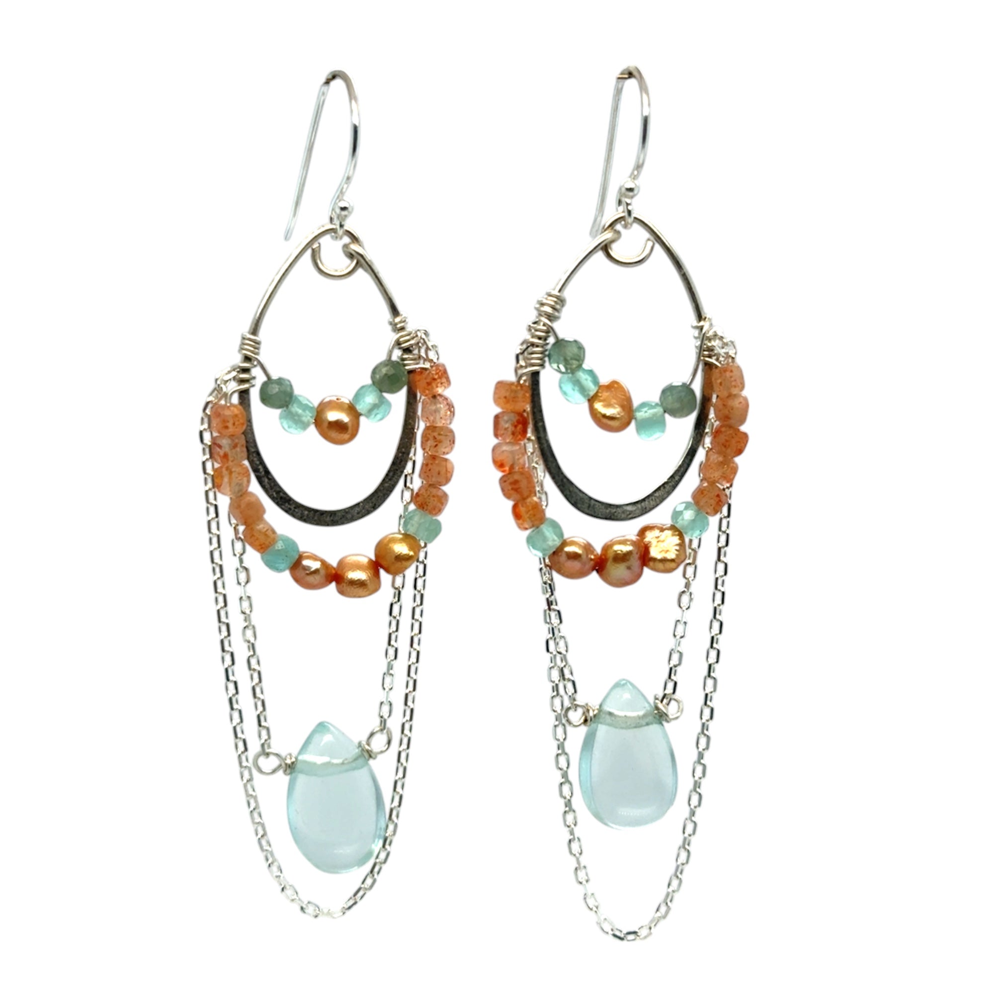 A pair of chandelier earrings featuring silver ovals, with sunstone, chalcedony, fresh water pearl, and apatite gemstones, and a single aqua quartz drop. 