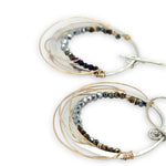 Sterling silver hammered hoop earrings lined with metallic crystal wrapped in gold filled wire