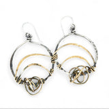 A pair of earrings featuring gestural knots of hand-formed hammered brass on oxidized sterling silver hoops