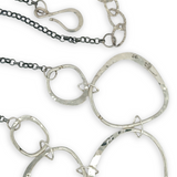 handmade hammered floral stamped sterling silver organic shapes varied in size hanging from oxidized sterling silver dainty chain necklace