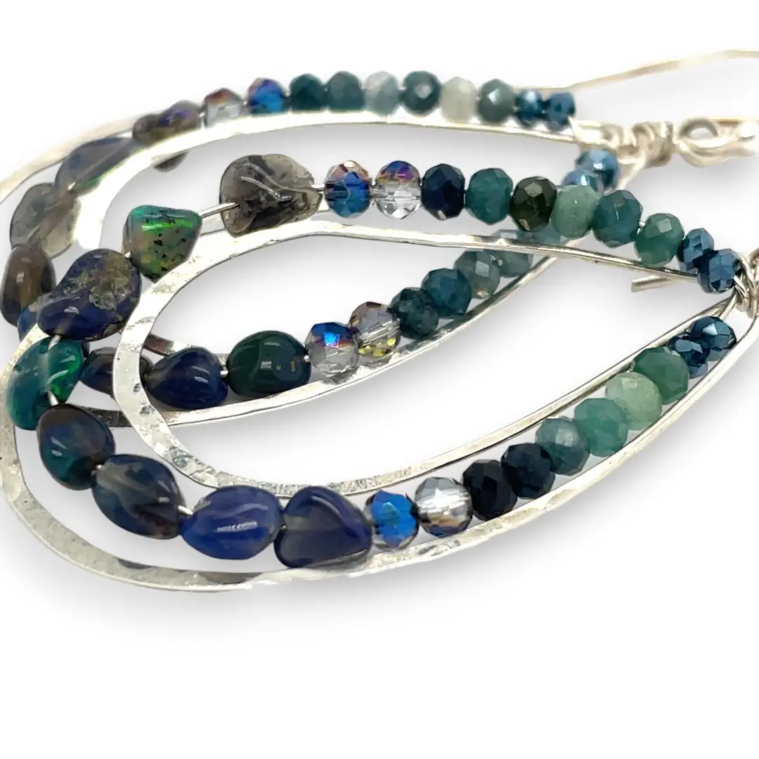 A pair of sterling silver channel drop earrings with blue opal nuggets and blue tourmaline micro faceted gemstones, featuring tiny crystal accents.