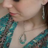 Moonstone drop gemstone held inside a sterling silver channel drop necklace lined with moss agate, amazonite, and terra verde jasper gemstones on a delicate sterling silver chain