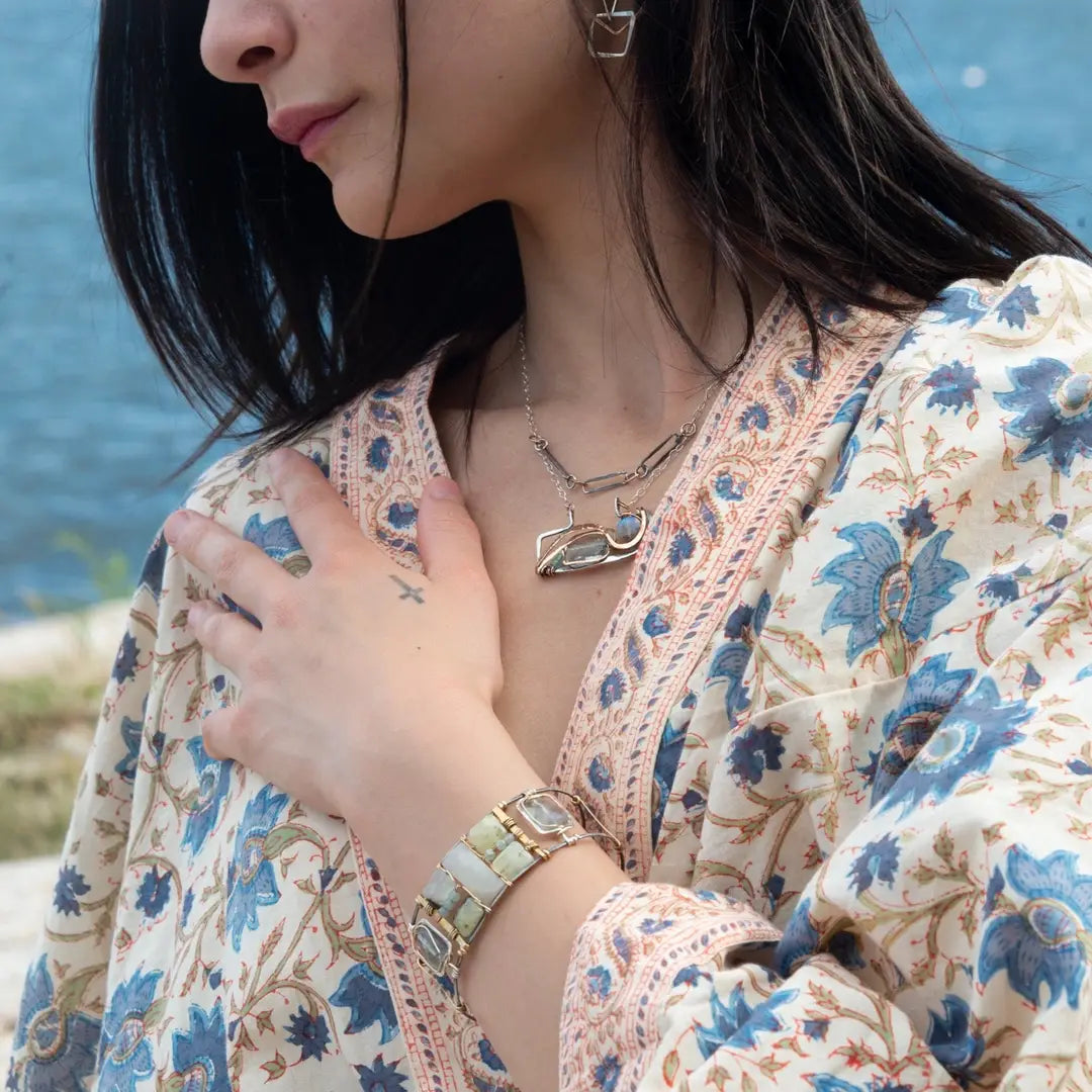 an oxidized sterling silver wide cuff bracelet with brass bars, featuring faceted moonstone, smooth prehnite, chalcedony, and fluorite gemstones on gold filled wire