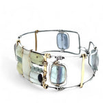 an oxidized sterling silver wide cuff bracelet with brass bars, featuring faceted moonstone, smooth prehnite, chalcedony, and fluorite gemstones on gold filled wire