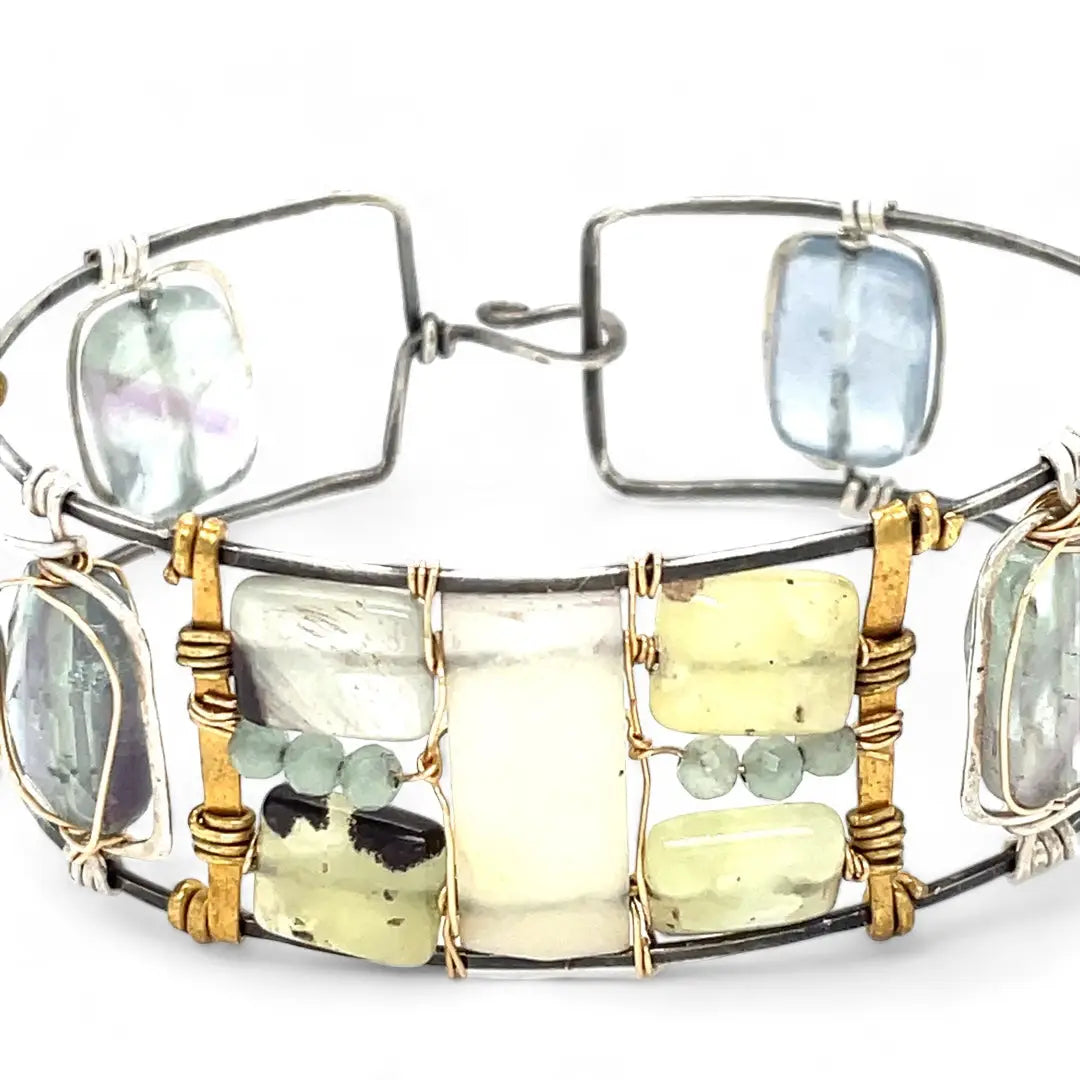 an oxidized sterling silver wide cuff bracelet with brass bars, featuring faceted moonstone, smooth prehnite, chalcedony, and fluorite gemstones on gold filled wire
