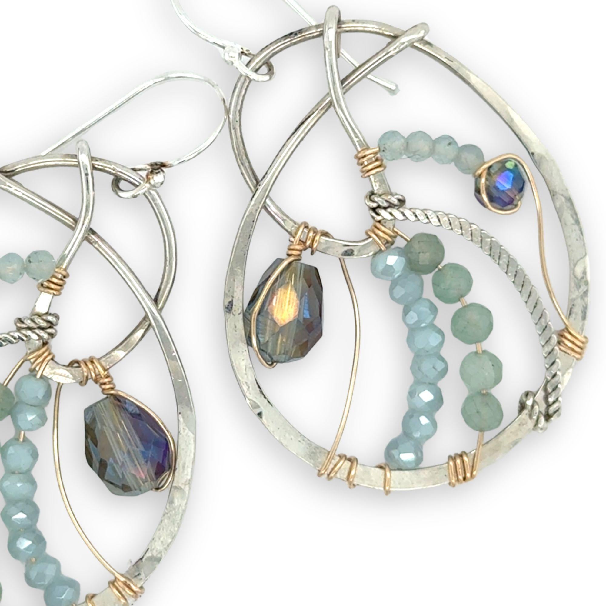 Aquamarine, amazonite, and crystal gemstones line the inside of our sterling silver nautilus shell earrings with gold filled wire