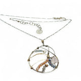 A sterling silver nautilus shell necklace with micro-faceted aquamarine and crystal beads along bronze lines, culminating in a faceted rose quartz gemstone center.