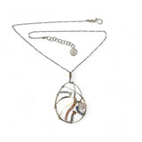 A sterling silver nautilus shell necklace with micro-faceted aquamarine and crystal beads along bronze lines, culminating in a faceted rose quartz gemstone center.