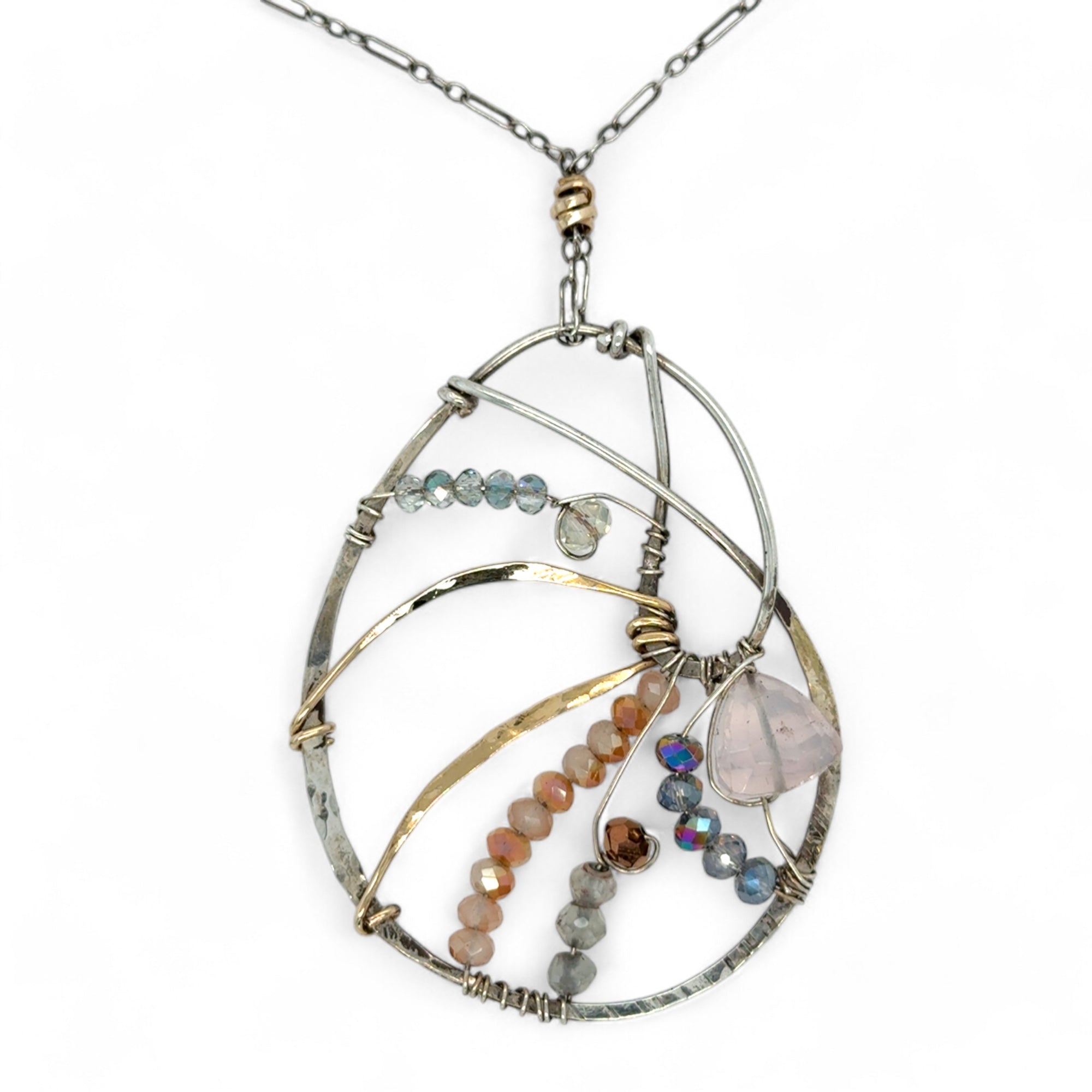 A sterling silver nautilus shell necklace with micro-faceted aquamarine and crystal beads along bronze lines, culminating in a faceted rose quartz gemstone center.