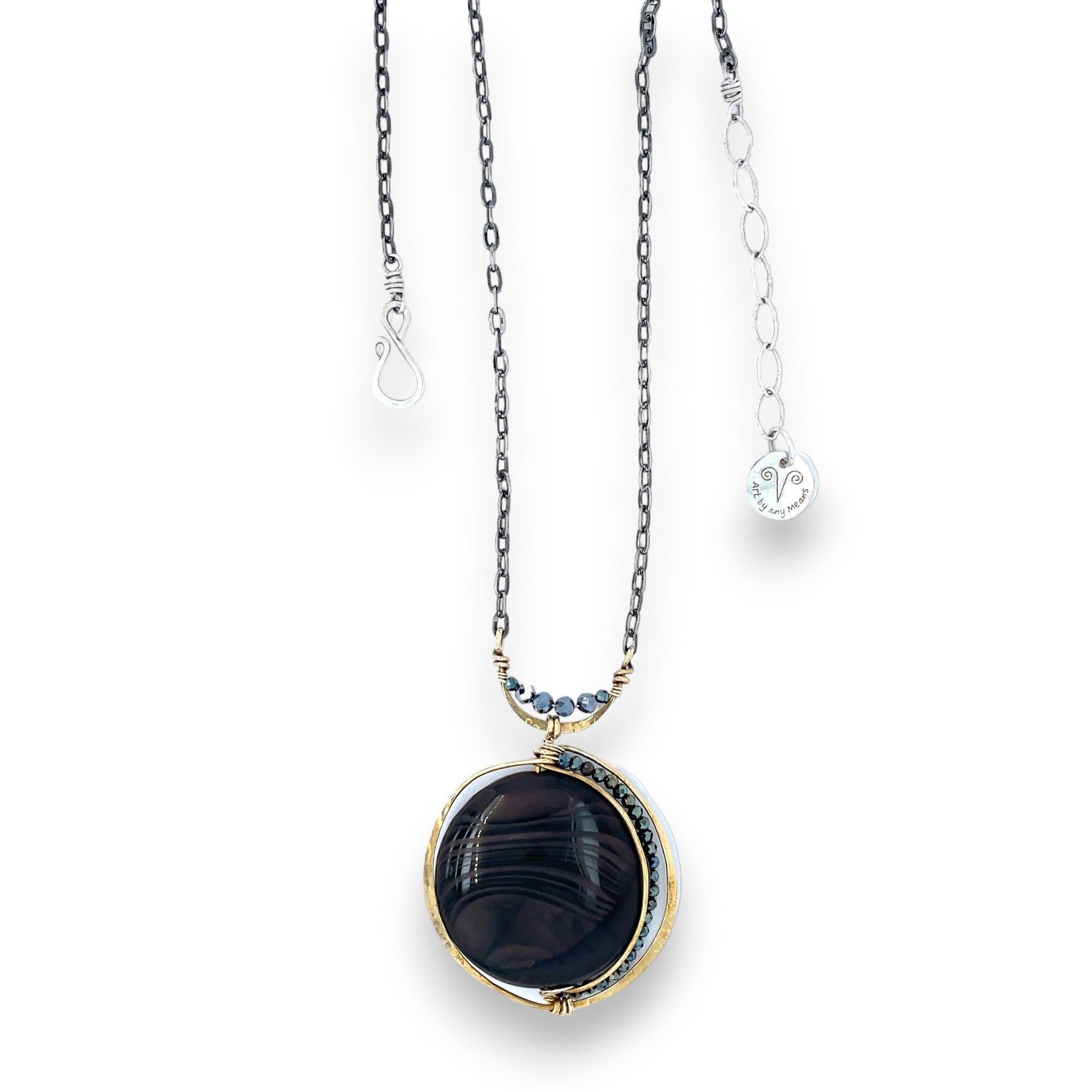 A necklace with a smooth brown jasper round gemstone, surrounded by faceted pyrite, set in hand-formed brass, with an adjustable darkened chain and sterling silver clasp.