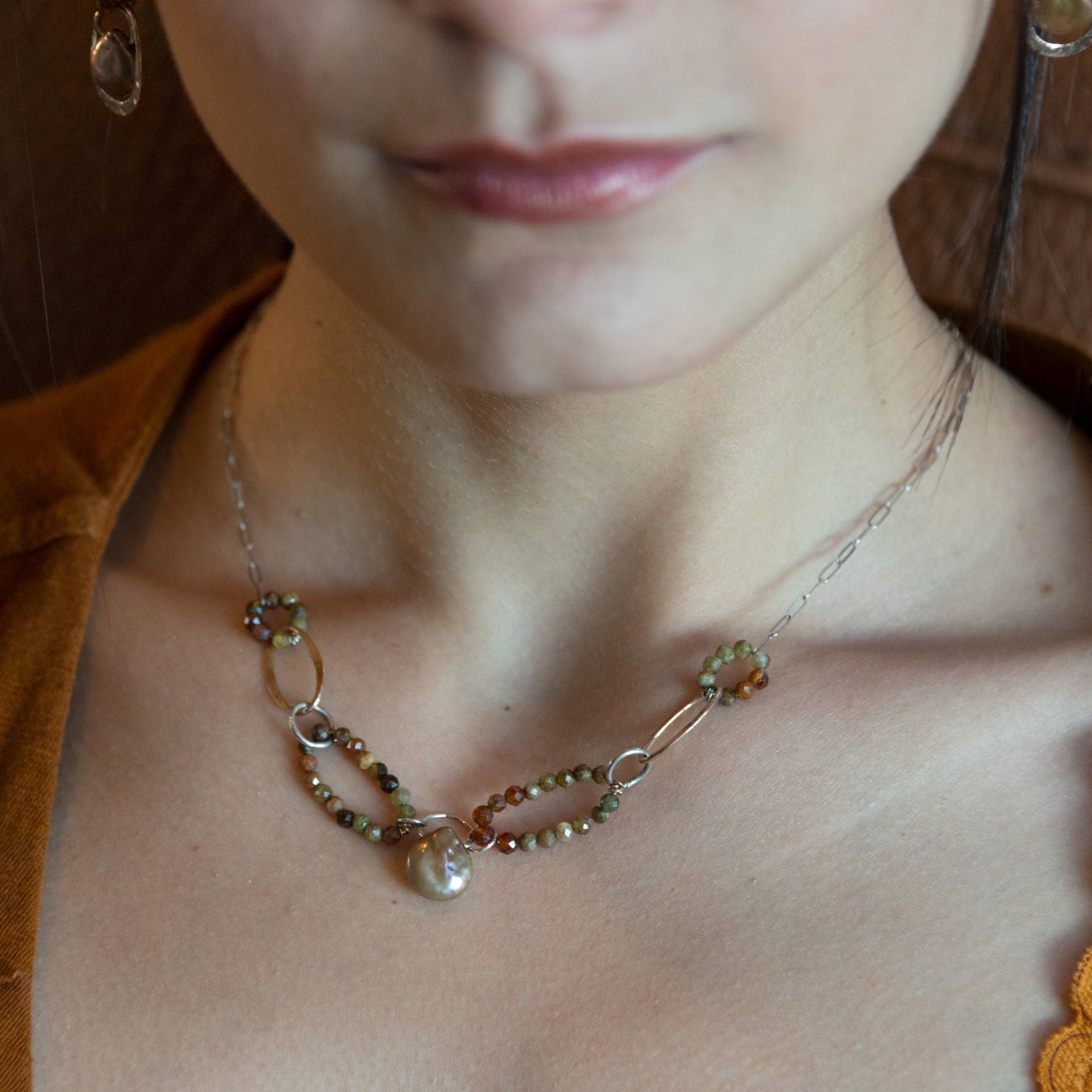 Hammered bronze links interspered with hessonite garnet links necklace on sterling silver chain hold a mauve/pink color fresh water pearl 