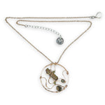 A collection of olive green fresh water pearls are woven in layers of gold filled hammered wire onto a handmade circle gold pendant necklace