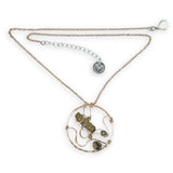 A collection of olive green fresh water pearls are woven in layers of gold filled hammered wire onto a handmade circle gold pendant necklace