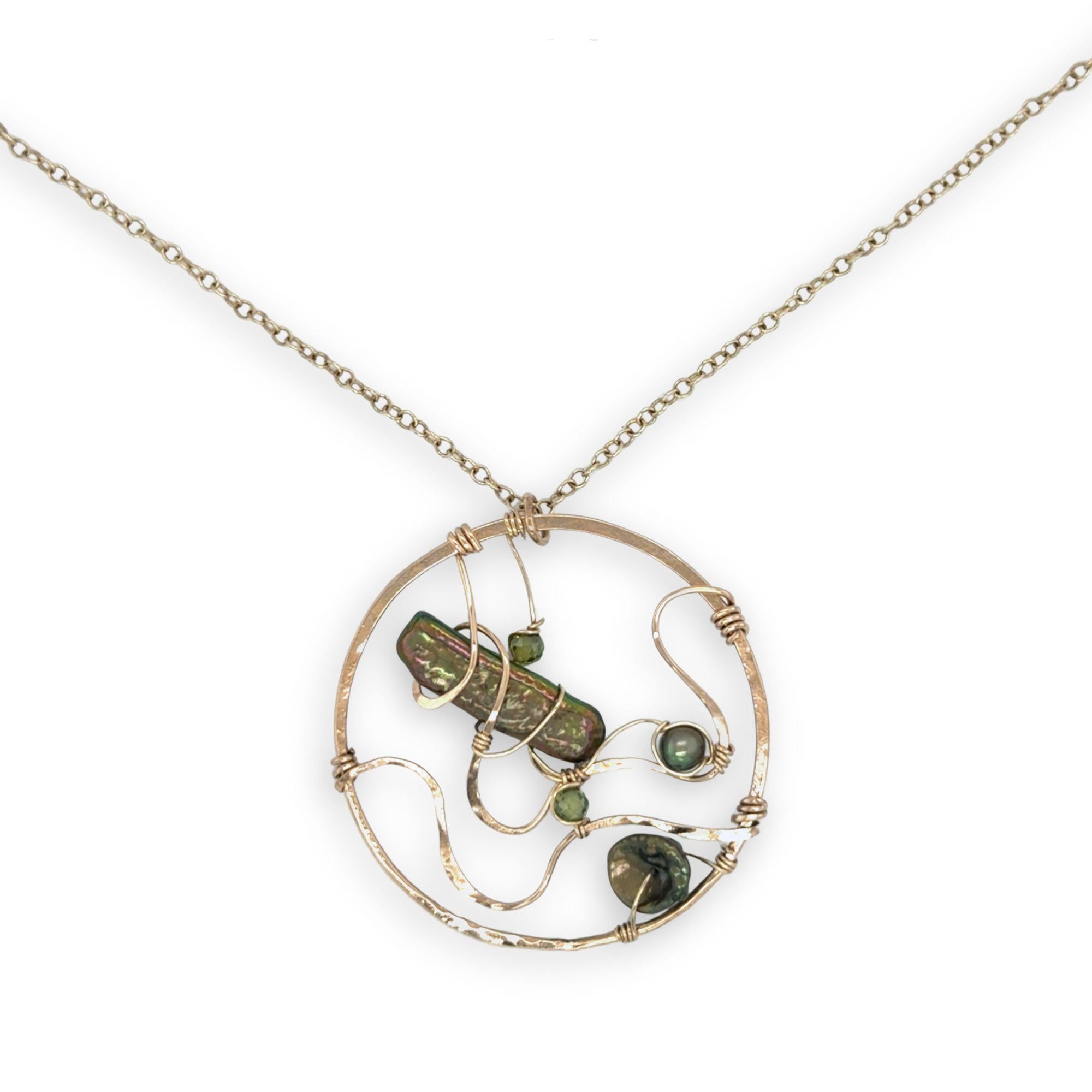 A collection of olive green fresh water pearls are woven in layers of gold filled hammered wire onto a handmade circle gold pendant necklace