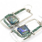 A pair of sterling silver hammered rectangle earrings with square cut blue-green crystals and faceted emerald gemstone cubes.