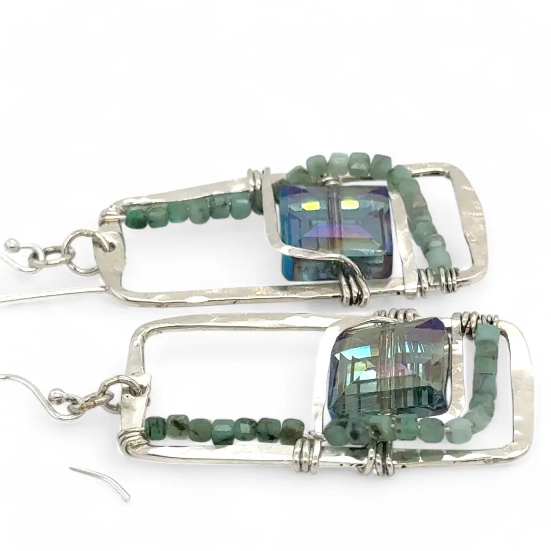 A pair of sterling silver hammered rectangle earrings with square cut blue-green crystals and faceted emerald gemstone cubes.