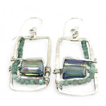 A pair of sterling silver hammered rectangle earrings with square cut blue-green crystals and faceted emerald gemstone cubes.