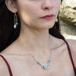 Sterling silver oval pendant with aquamarine nugget wrapped in bronze hammered wire with blue zoisite, and crystal gemstones on a sterling silver chain necklace