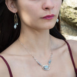Sterling silver oval pendant with aquamarine nugget wrapped in bronze hammered wire with blue zoisite, and crystal gemstones on a sterling silver chain necklace