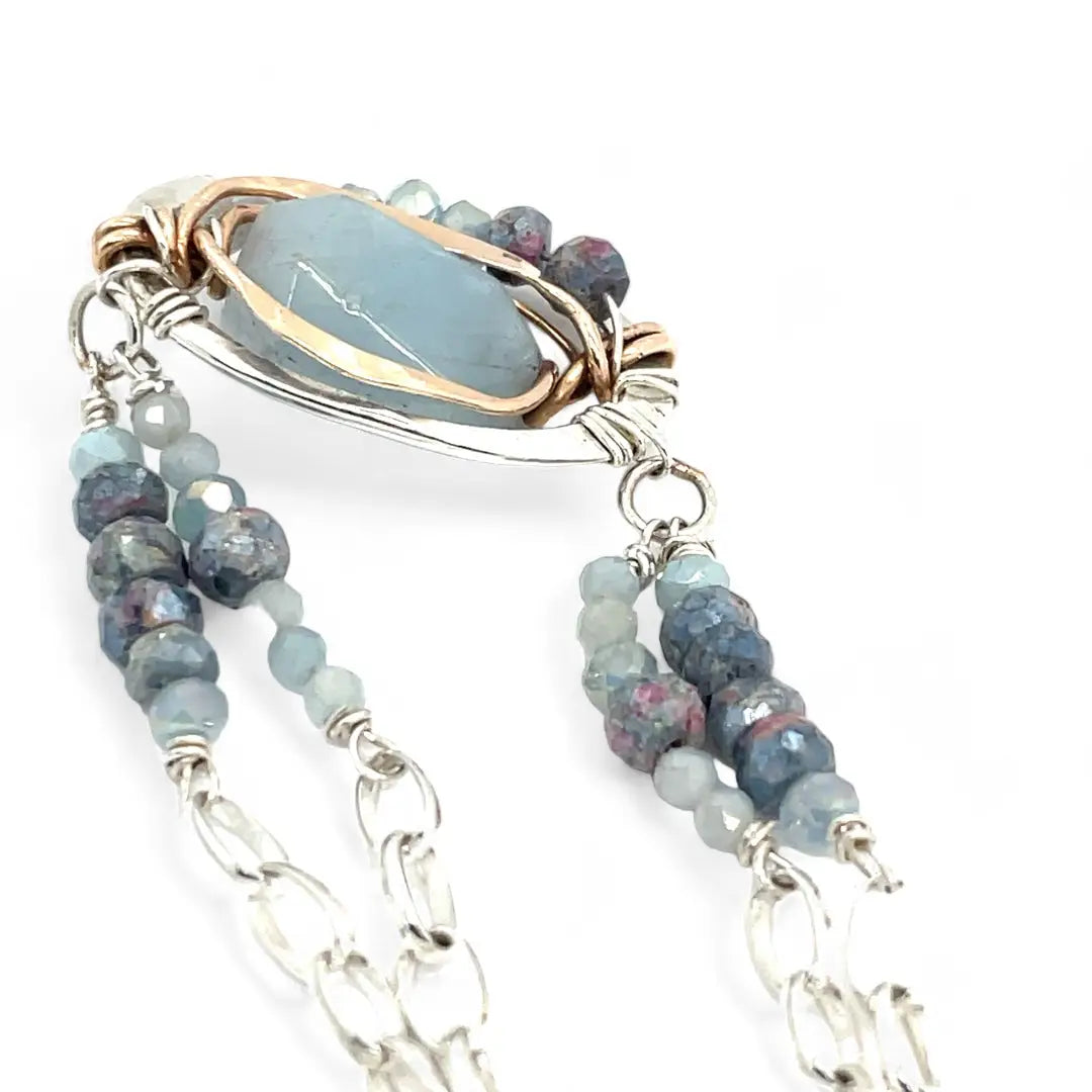 Sterling silver oval pendant with aquamarine nugget wrapped in bronze hammered wire with blue zoisite, and crystal gemstones on a sterling silver chain necklace