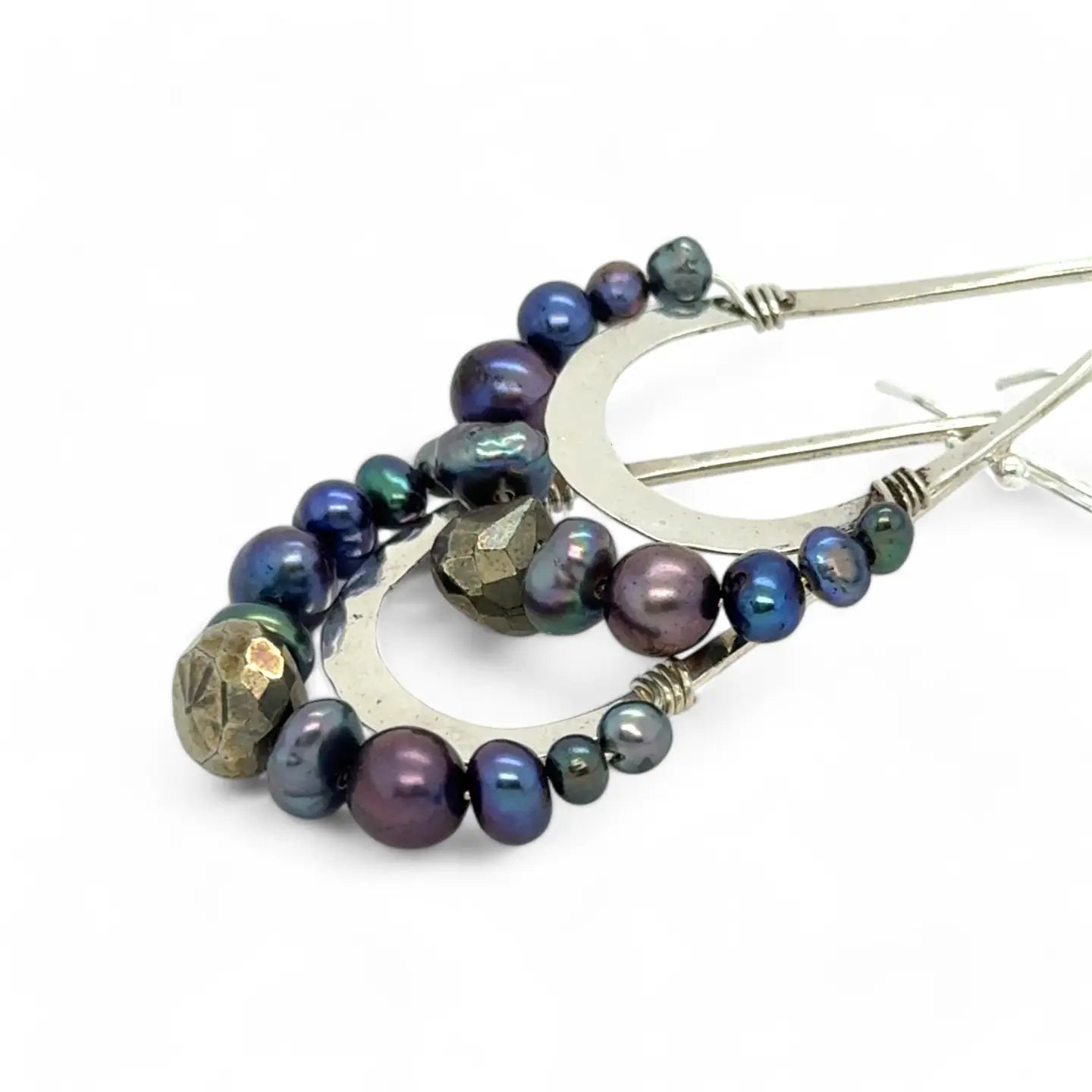 Blue/ purple fresh water pearls and a pyrite drop gemstones sit at the bottom of our handmade hammered sterling silver drop earrings