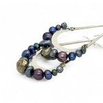 Blue/ purple fresh water pearls and a pyrite drop gemstones sit at the bottom of our handmade hammered sterling silver drop earrings