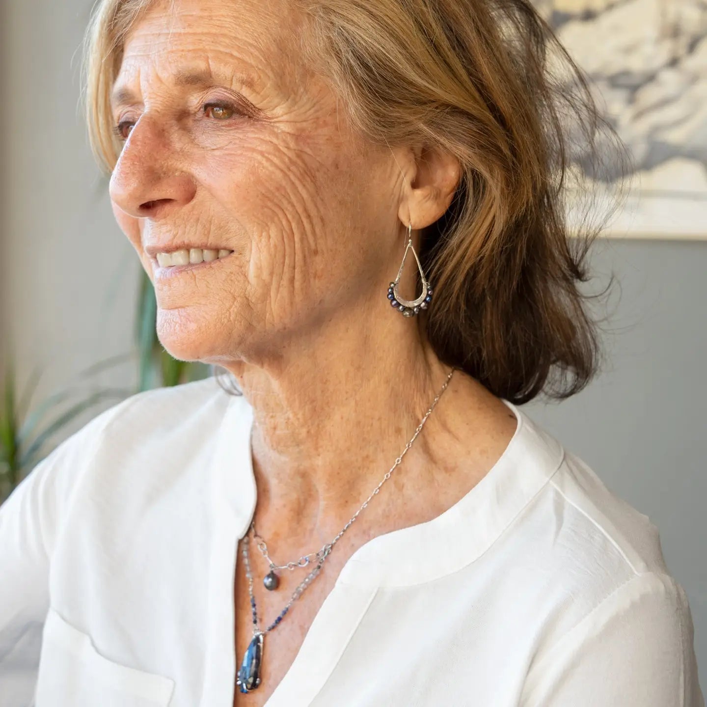 Blue/ purple fresh water pearls and a pyrite drop gemstones sit at the bottom of our handmade hammered sterling silver drop earrings
