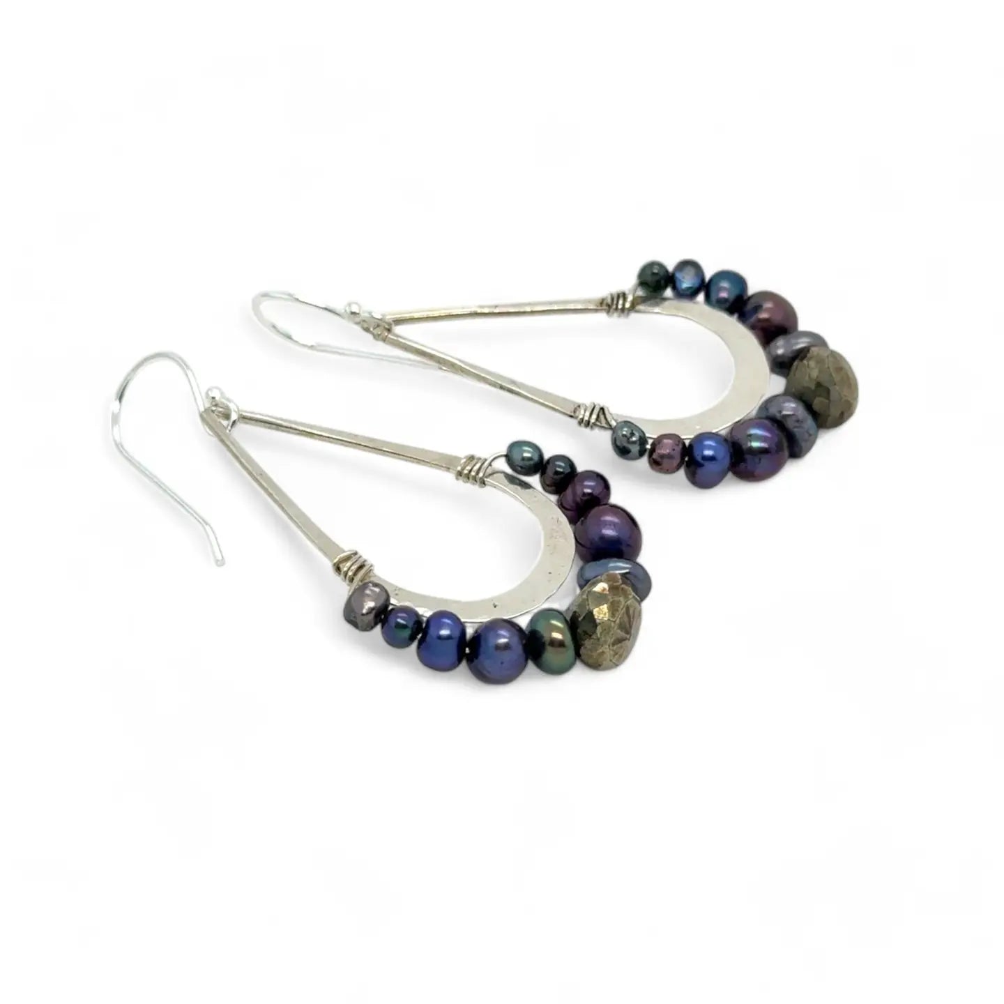 Blue/ purple fresh water pearls and a pyrite drop gemstones sit at the bottom of our handmade hammered sterling silver drop earrings