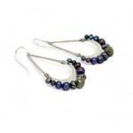 Blue/ purple fresh water pearls and a pyrite drop gemstones sit at the bottom of our handmade hammered sterling silver drop earrings