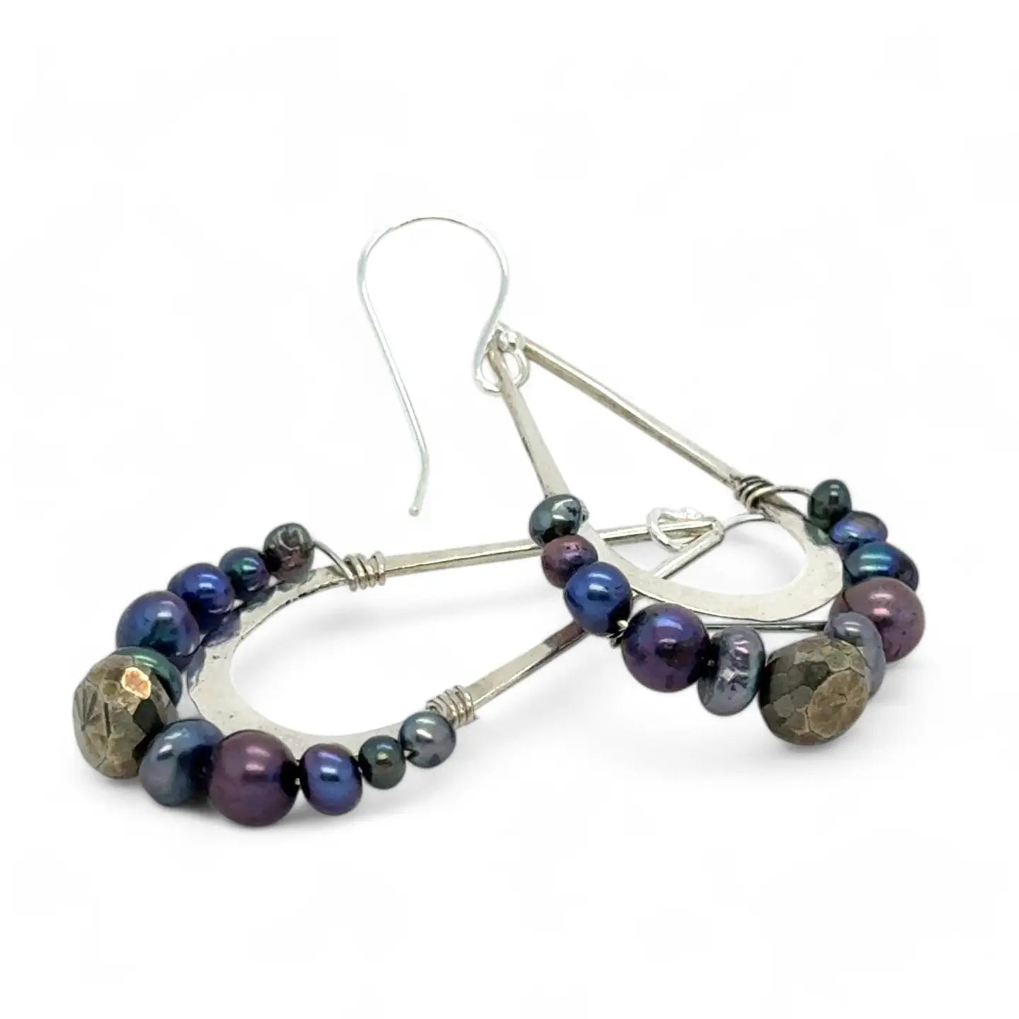 Blue/ purple fresh water pearls and a pyrite drop gemstones sit at the bottom of our handmade hammered sterling silver drop earrings