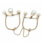 A pair of brass hammered open archway earrings with freshwater pearls attached to them
