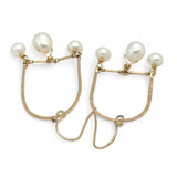 A pair of brass hammered open archway earrings with freshwater pearls attached to them