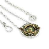sterling silver dot wire ring pendant with olive green fresh water pearl coin surrounded by hammered brass and green cubic zirconia and pyrite necklace