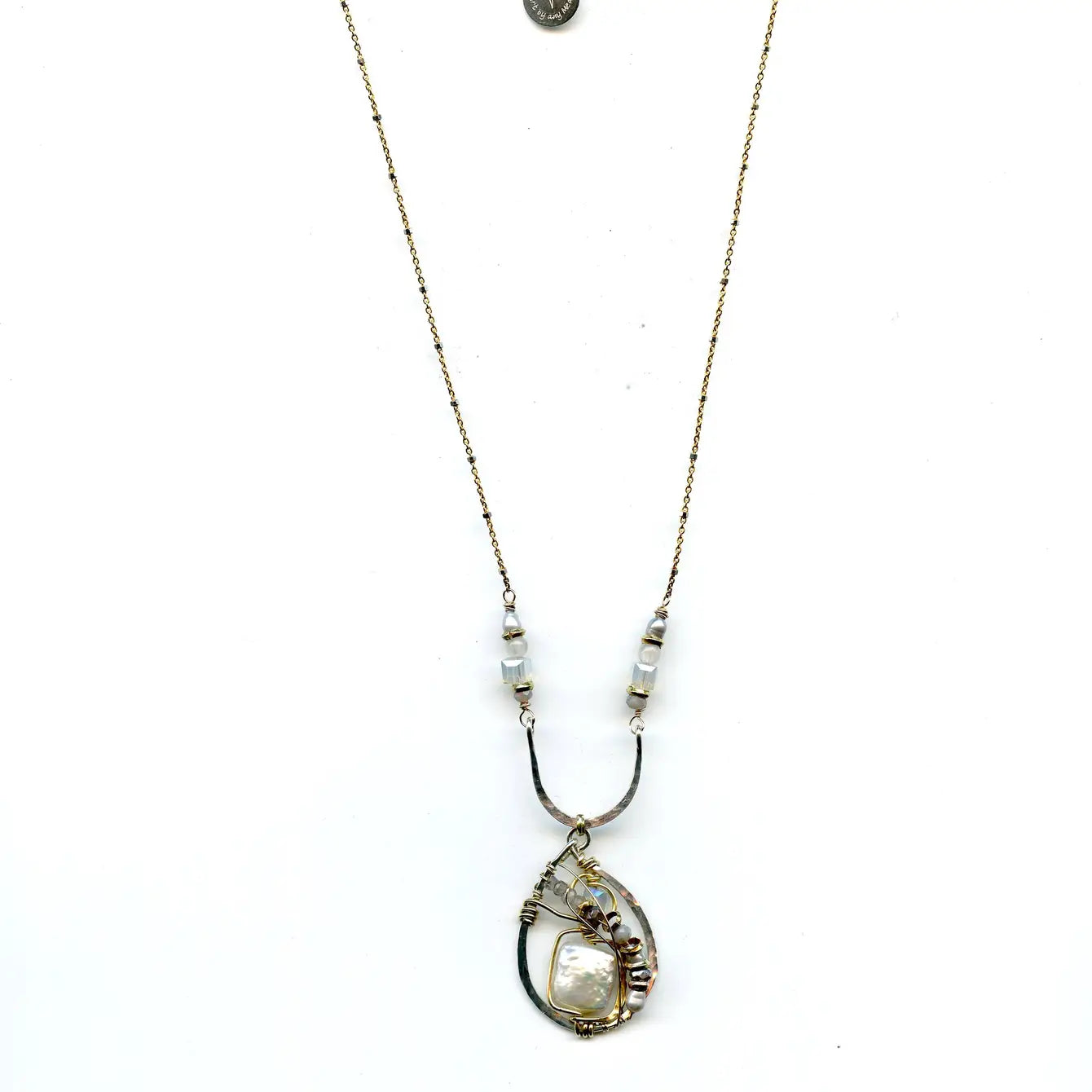 Fresh water pearl tile surrounded by labradorite, crystal, brass, and silver pearl gemstones in a handmade hammered sterling silver drop hanging from a sterling arch. 