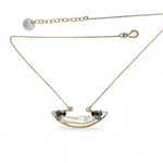 A gold-filled chain necklace with a boat-shaped brass pendant featuring a freshwater pearl stick and aquamarine gemstones at the bow and stern.