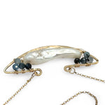 A gold-filled chain necklace with a boat-shaped brass pendant featuring a freshwater pearl stick and aquamarine gemstones at the bow and stern.