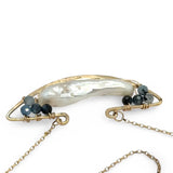 A gold-filled chain necklace with a boat-shaped brass pendant featuring a freshwater pearl stick and aquamarine gemstones at the bow and stern.