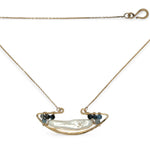 A gold-filled chain necklace with a boat-shaped brass pendant featuring a freshwater pearl stick and aquamarine gemstones at the bow and stern.