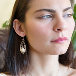 A pair of pearl drop earrings with hammered brass and oxidized sterling silver, featuring micro faceted rutilated quartz details.