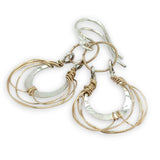 Sterling silver handmade mini earrings woven with gold filled wire hanging from a braided gold filled link