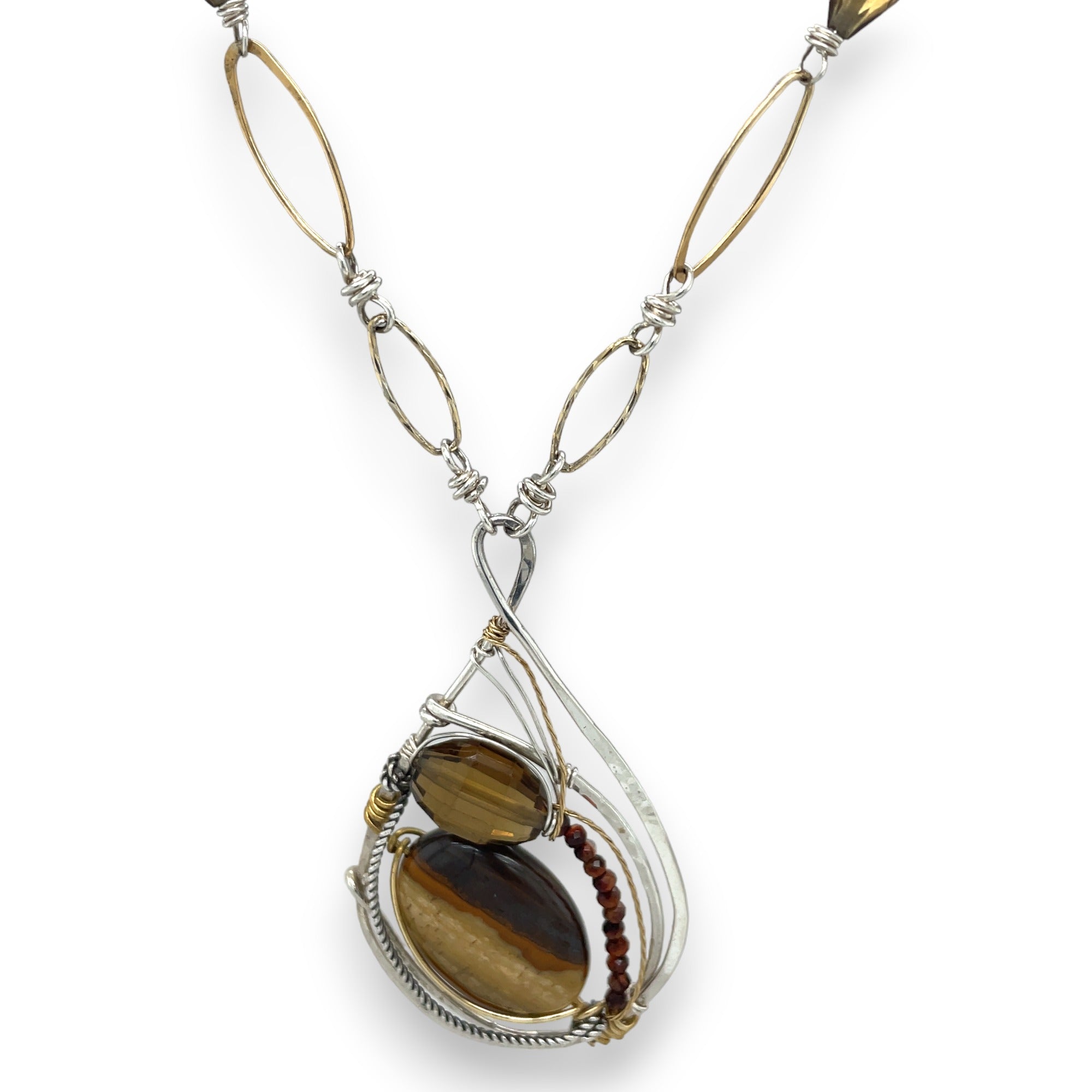 Petrified wood, smokey quartz, and tiger's eye gemstones fill a sterling silver pendant necklace with gold fill accents