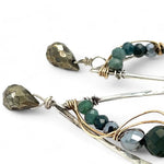 A pair of sterling silver drop earrings with gold-filled wiring and dark green faceted bloodstone and blue tourmaline gemstones with silver pyrite drops.