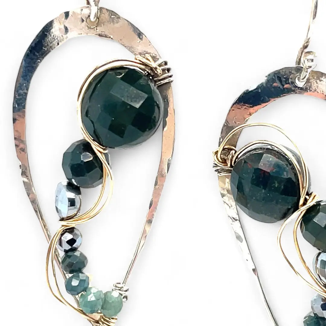 A pair of sterling silver drop earrings with gold-filled wiring and dark green faceted bloodstone and blue tourmaline gemstones with silver pyrite drops.