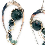 A pair of sterling silver drop earrings with gold-filled wiring and dark green faceted bloodstone and blue tourmaline gemstones with silver pyrite drops.