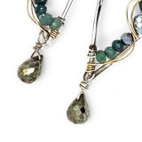 A pair of sterling silver drop earrings with gold-filled wiring and dark green faceted bloodstone and blue tourmaline gemstones with silver pyrite drops.