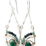 A pair of sterling silver leaf earrings with faceted green amethyst and blue tourmaline gemstones, wrapped in hand-formed hammered brass with sterling silver tube chain tops