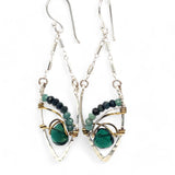 A pair of sterling silver leaf earrings with faceted green amethyst and blue tourmaline gemstones, wrapped in hand-formed hammered brass with sterling silver tube chain tops