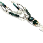A sterling silver double chain necklace with adjuster, featuring dark green fresh water pearl, dark green amethyst drop, faceted blue tourmaline ombre gemstones, green amethyst, and oxidized sterling silver diamond cut links 
